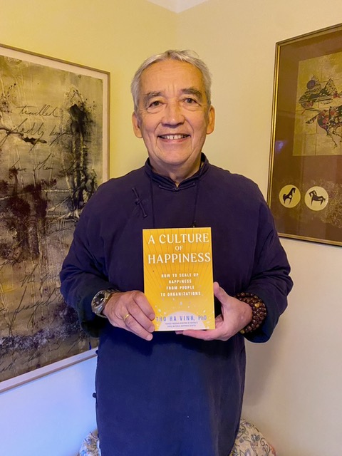 Author Tho Ha Vinh holding A Culture of Happiness